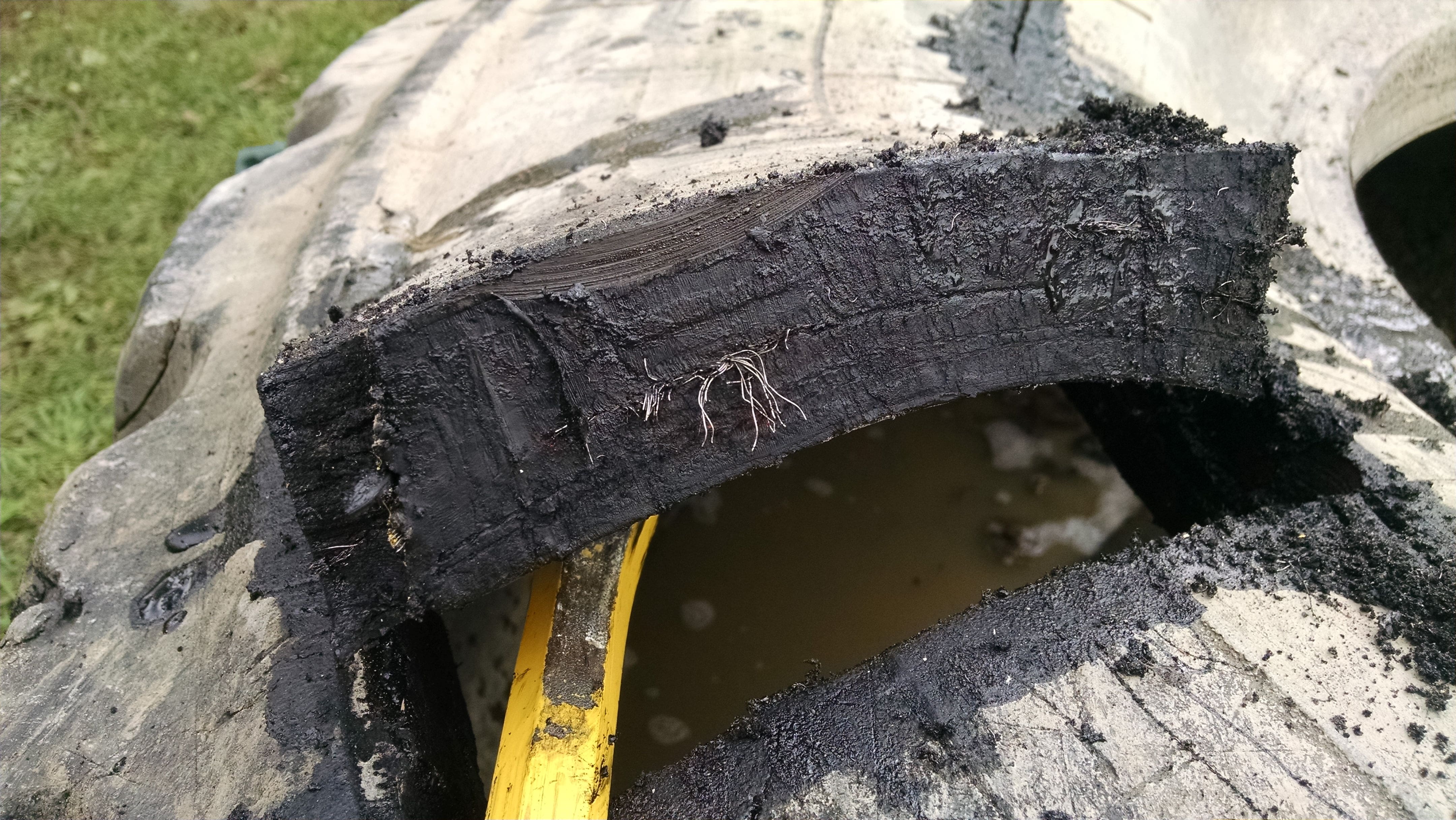 It helps to pry up on the sidewall while cutting. This sidewall is about 1-1/2 inches thick with several sandwiched layers of rubber and steel.