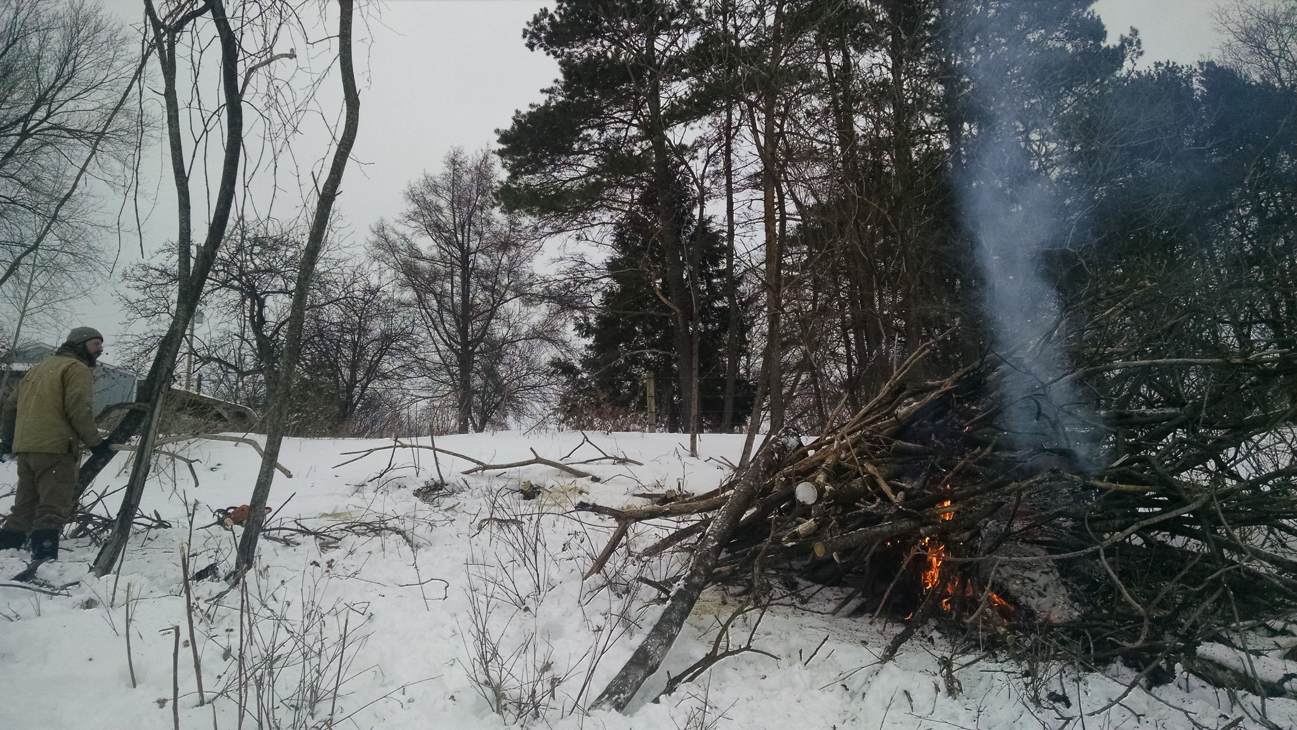Starting the burn. AJ and Allie helped get the fire started by packing a dense core of dry branches and cardboard scraps. Harry didn't help per se; he spent his time figuring out how much other stuff he could catch on fire.