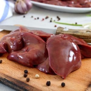 Pasture Raised, Certified Organic Turkey Livers from Wrong Direction Farm on a cutting board with peppercorns and garlic.