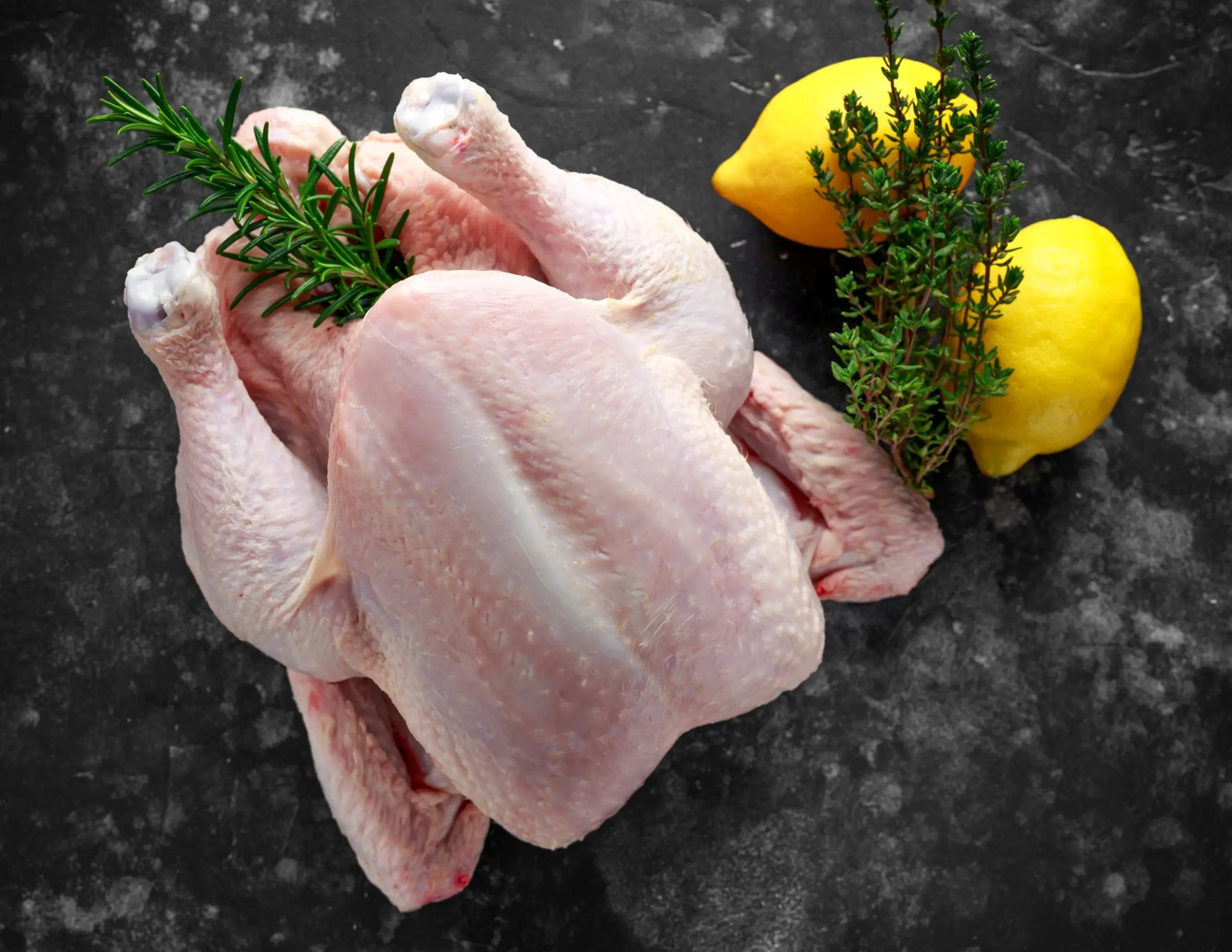 Raw pasture raised chicken with rosemary and lemon.