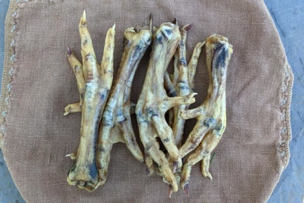 Dried pasture raised and certified organic chicken feet on a cloth backdrop
